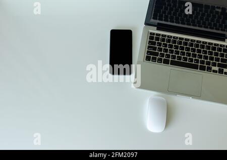 Computer portatile, smartphone e mouse sullo sfondo Visualizza.Copia spazio Foto Stock