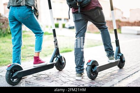 Primo piano di pendolari cittadini che utilizzano scooter elettrico in città park - studenti milleniali che cavalcano un nuovo mezzo ecologico moderno di Trasporti - energia ecologica Foto Stock