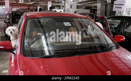 Mumbai, India. 05 maggio 2021. Un operatore sanitario che indossa una maschera facciale somministra una dose di vaccino COVID19 ad una donna all'interno della sua auto al parcheggio pubblico Kohinoor a Mumbai. Questa struttura è aperta per soddisfare gli anziani e le persone diversamente abili. Credit: SOPA Images Limited/Alamy Live News Foto Stock