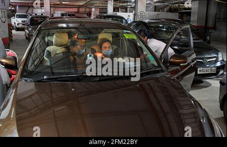 Mumbai, India. 05 maggio 2021. Un operatore sanitario che indossa una maschera facciale somministra una dose di vaccino COVID19 ad una donna all'interno della sua auto al parcheggio pubblico Kohinoor a Mumbai. Questa struttura è aperta per soddisfare gli anziani e le persone diversamente abili. (Foto di Ashish Vaishnav/SOPA Images/Sipa USA) Credit: Sipa USA/Alamy Live News Foto Stock