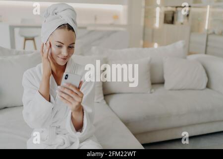 Donna beauty blogger creare video su smartphone per il suo vlog sulla routine quotidiana della cura della pelle Foto Stock