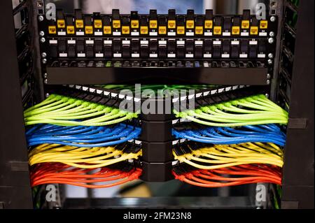 Al sistema sono collegate file multicolore di cavi di rete Foto Stock