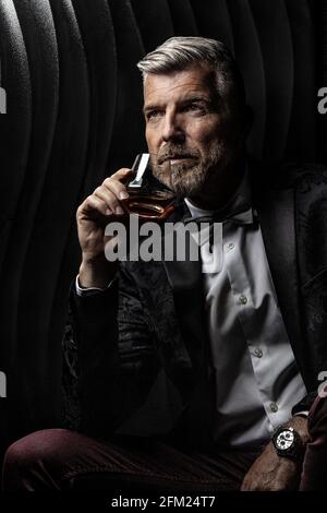 Ritratto di un gentiluomo che tiene un bicchiere di alcol Foto Stock