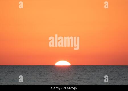 Primo piano del tramonto in un cielo perfettamente limpido sopra l'oceano Foto Stock