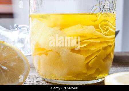 Bucce di limone infuse in un vasetto di alcool per il produzione di limoncello fatto in casa Foto Stock