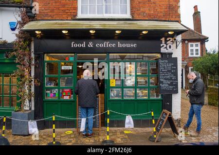 Old Amersham, Buckinghamshire, Regno Unito. 22 febbraio 2021. La gente aspetta all'esterno di una caffetteria. Il primo ministro Boris Johnson ha oggi delineato la tabella di marcia per l'Inghilterra che esce dal blocco Covid-19. Nel frattempo Old Amersham rimane molto tranquilla, come la gente ha prestato attenzione al governo Covid-19 Lockdown consigli per rimanere a casa. Credito: Maureen McLean/Alamy Foto Stock