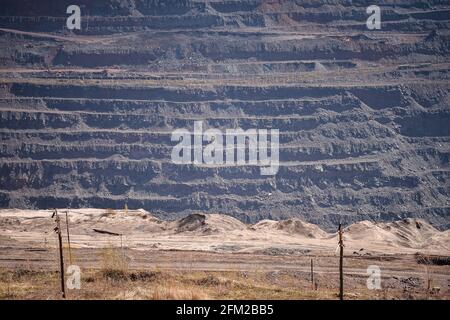 Vista di una parte di una cava di minerale di ferro con un treno ferroviario con terrazze per l'esportazione di minerale. Sfondo. Copiare lo spazio. Foto Stock