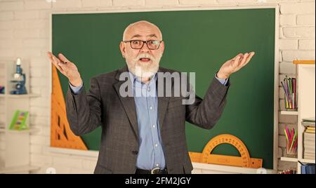 Ottenere le certificazioni per programmi specifici. Insegnante di uomo intelligente senior presso la lavagna. Insegnante di vecchia generazione scolastica. Docente esperto Foto Stock