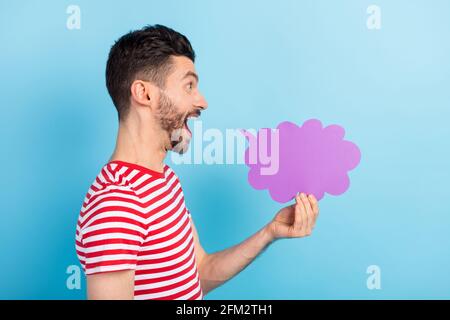 Foto di simpatico ragazzo giovane indossare vestito rosso tenuta nuvola parlante spazio vuoto bocca aperta isolato sfondo blu Foto Stock