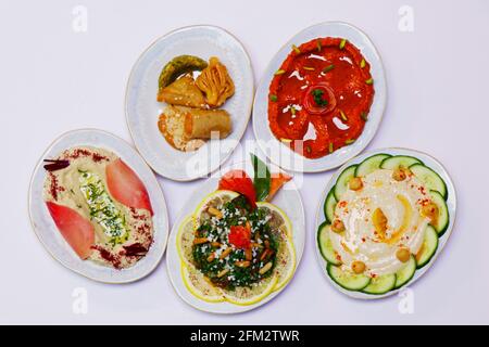 le mezze alimentari libanesi, il cibo arabico comprende hummus, muhammara, moutabal, taboule e foglie di vite Foto Stock