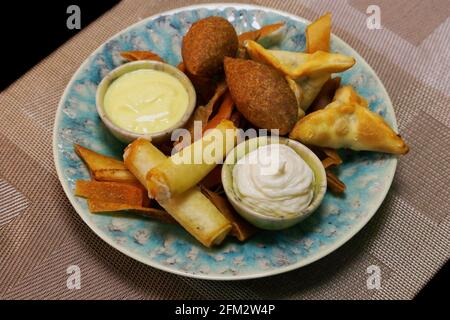 specialità di cibo arabico libanese la selezione di mezze calde fritte include ingrasso di spinaci, involtini di formaggio e kebe di agnello, cibo orientale meddle Foto Stock