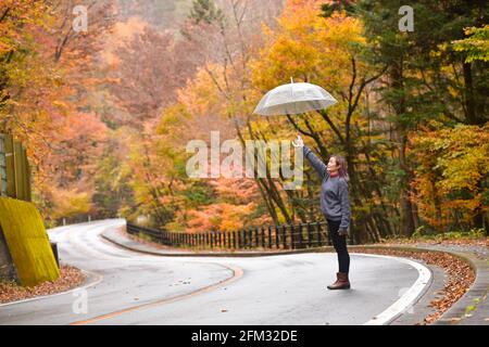 Donna in piedi nel mezzo della strada che tiene un ombrello, Honshu, Giappone Foto Stock