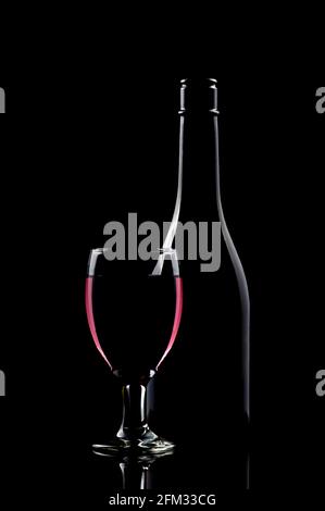 Bicchiere di vino rosso accanto a una bottiglia su un tabella Foto Stock