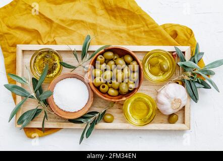 Vista dall'alto di tre diverse pentole di olio d'oliva con olive, aglio e condimento su un vassoio Foto Stock