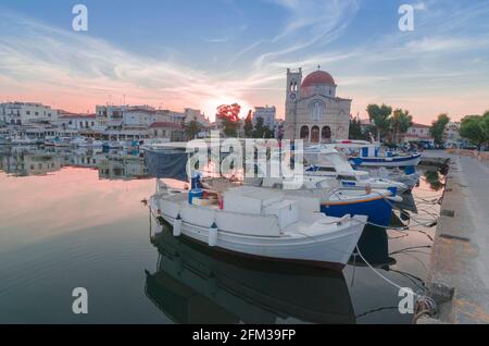 Porto di affascinante città di Egina con yacht e barche di pescatori ormeggiati nell'isola di Egina, Golfo Saronico, Grecia, al tramonto. Foto Stock