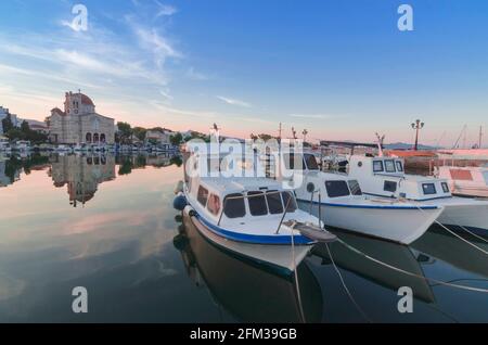 Porto di affascinante città di Egina con yacht e barche di pescatori ormeggiati nell'isola di Egina, Golfo Saronico, Grecia, al tramonto. Foto Stock