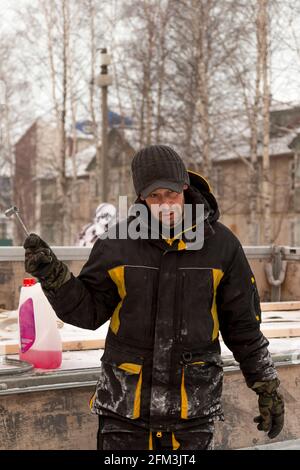 Ritratto di un operaio in un cappello nero e con una chiave in mano Foto Stock