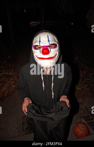 Trucco o treater di Halloween in costume che indossa la maschera di scherzo. St Paul Minnesota, Minnesota, Stati Uniti Foto Stock