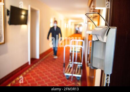 Horumersiel, Germania. 05 maggio 2021. Nel corridoio dell'hotel si trova un dispenser di disinfettante. Dal 10 maggio 2021, i pernottamenti turistici nella bassa Sassonia fuori dai punti caldi di Corona saranno nuovamente possibili, inizialmente solo per i residenti dello stato. Potranno poi effettuare nuovamente il check-in in hotel, appartamenti e campeggi, insieme a test rapidi negativi o prove di vaccinazione. Credit: Sina Schuldt/dpa/Alamy Live News Foto Stock