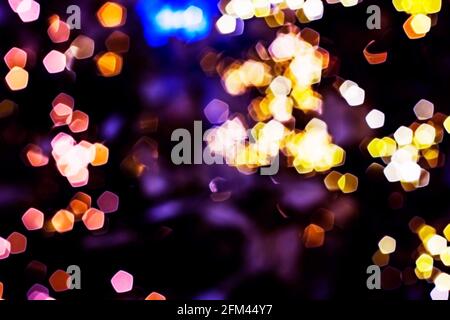 Luci offuscate sfondo astratto di notte, sfocato sfondo bokeh scuro e luminoso, magico motivo luminoso illuminato. Foto Stock