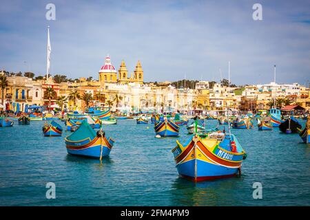 malta - porto di marsaxlockk pieno di barche tipiche chiamato luzzu Foto Stock