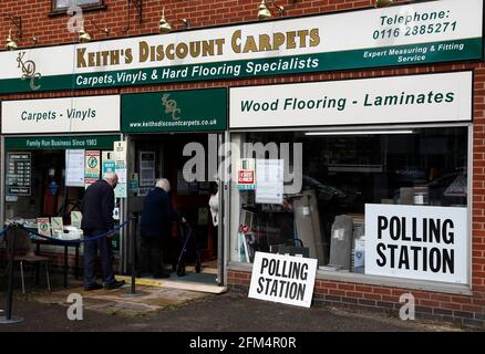 Wigston, Leicestershire, Regno Unito. 6 maggio 2021. Gli elettori entrano in una stazione di polling in un negozio di tappeti durante le elezioni locali. Milioni di persone in tutta la Gran Bretagna faranno uno scrutinio giovedì nella più grande serie di voti dalle elezioni generali del 2019. Credit Darren Staples/Alamy Live News. Foto Stock