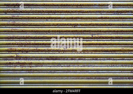 Linee orizzontali di persiane in metallo giallo Rusty Foto Stock