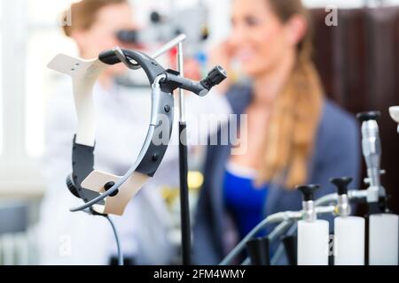 Medico - Giovani donne medico o specialista ORL - con un paziente nella sua pratica, esaminando l'orecchio con un endoscopio Foto Stock