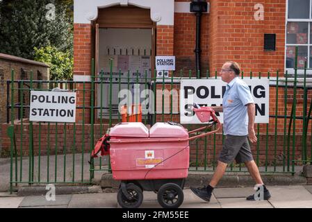 Postino che passa un seggio a Westcliff on Sea, Essex, Regno Unito. Tipica sede di polling esterna, sede in un vecchio edificio. Concetto di voto postale Foto Stock