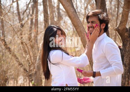 Giovane uomo e donna che festeggia la festa di Holi con polvere colorata sulla faccia Foto Stock