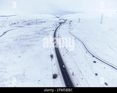 Dalwhinnie, Scozia, Regno Unito. 6 maggio 2021. Vista aerea del paesaggio innevato nel Passo di Drumochter ad alta quota a Dalwhinnie nelle Highlands scozzesi. PIC; l'autostrada A9 si snoda verso nord attraverso un Passo Drumochter coperto di neve. Iain Masterton/Alamy Live News Foto Stock
