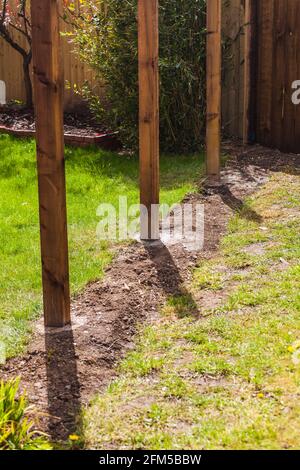 Nuovi pali recinzione impostati in cemento in un giardino in Stockton on Tees, Inghilterra, Regno Unito Foto Stock