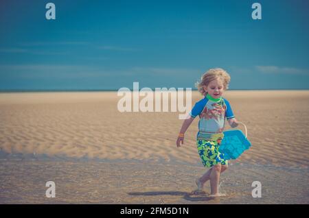 Giovane ragazzo che gioca sulla spiaggia Foto Stock