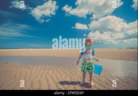 Giovane ragazzo che gioca sulla spiaggia Foto Stock