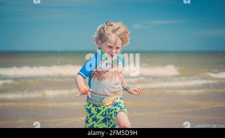 Giovane ragazzo che gioca sulla spiaggia Foto Stock