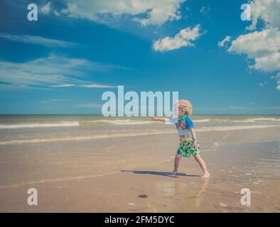 Giovane ragazzo che gioca sulla spiaggia Foto Stock