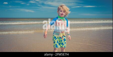 Giovane ragazzo che gioca sulla spiaggia Foto Stock