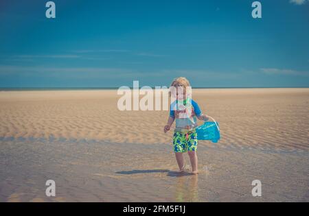 Giovane ragazzo che gioca sulla spiaggia Foto Stock