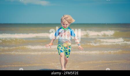 Giovane ragazzo che gioca sulla spiaggia Foto Stock