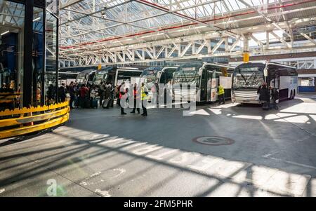 Stazione dei pullman Victoria di Londra. I passeggeri in attesa pazientemente in coda mentre salono a bordo di un pullman National Express presso la più grande stazione degli autobus di Londra. Foto Stock