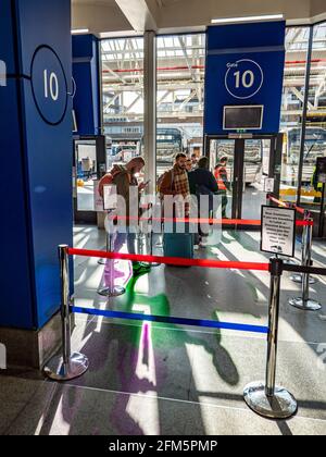 Stazione dei pullman London Victoria; Gate 10. Passeggeri e viaggiatori che aspettano pazientemente presso un cancello d'imbarco nel più grande terminal degli autobus di Londra. Foto Stock