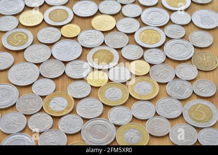 Monete di zloty polacca su uno sfondo con una texture di legno in un primo piano fotografico. Vicino Foto Stock