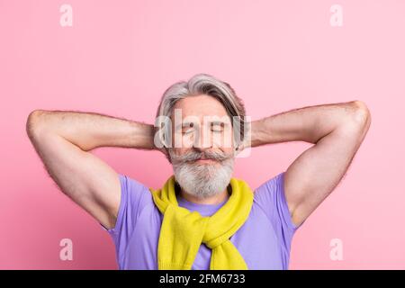 Primo piano ritratto di un simpaticante uomo dai capelli grigi che riposa libero tempo isolato su sfondo di colore pastello rosa Foto Stock