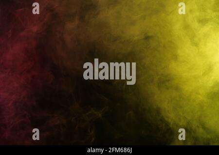 Fumo artificiale in luce rosso-gialla su sfondo nero Foto Stock