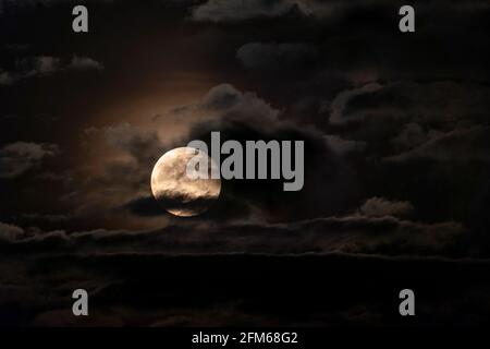 Cielo notturno spooky con luna piena parzialmente nascosto dalle nuvole Foto Stock