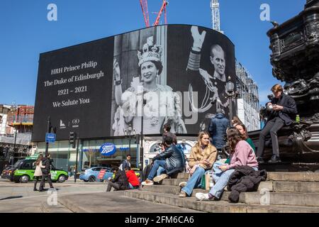 La gente si ferma a guardare il famoso schermo pubblicitario a Piccadilly Circus come ha mostrato un tributo per il principe Filippo, il giorno del suo funerale, Regno Unito Foto Stock