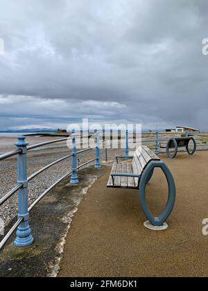 Posti a sedere in panchina lungo la passeggiata Morecambe vicino al Midland Hotel Foto Stock