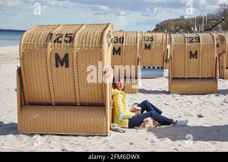 06 maggio 2021, Schleswig-Holstein, Kiel: Monika Veselsky gode del sole sulla spiaggia. Dopo la decisione di ulteriori passi di apertura nel turismo e nella gastronomia dello Schleswig-Holstein, la regione si prepara. Foto: Georg Wendt/dpa Foto Stock