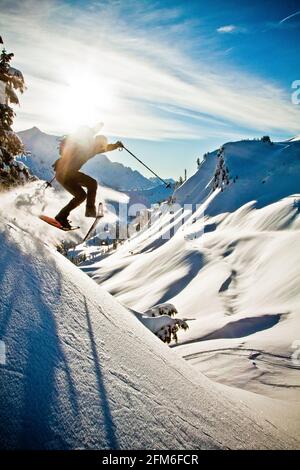 L'uomo che indossa le racchette da neve salta da una ripida banca vicino a Artist's Point. Foto Stock