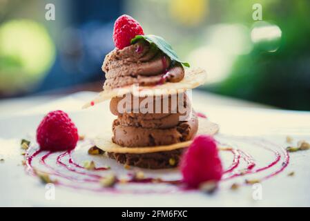 Dessert di mousse al cioccolato con pasta sfoglia e lamponi in ristorante Foto Stock